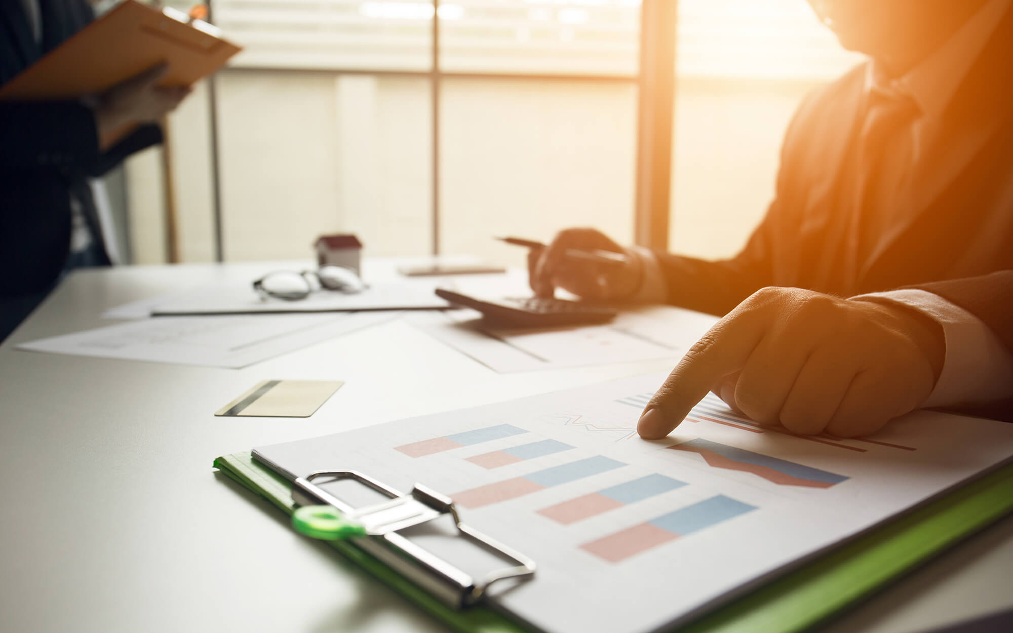 A finger pointing to charts on a paper